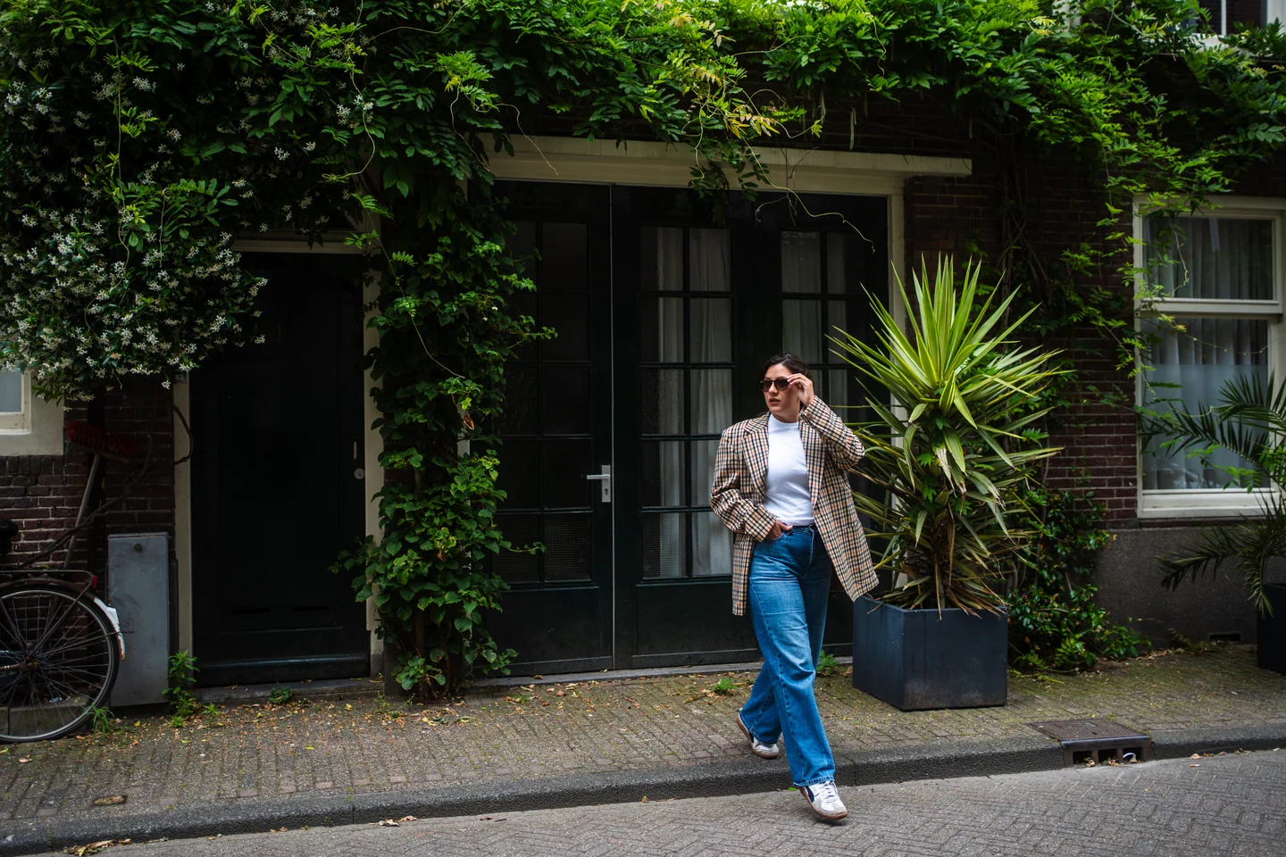 Andrea on a street surrounded by climbing greenery
