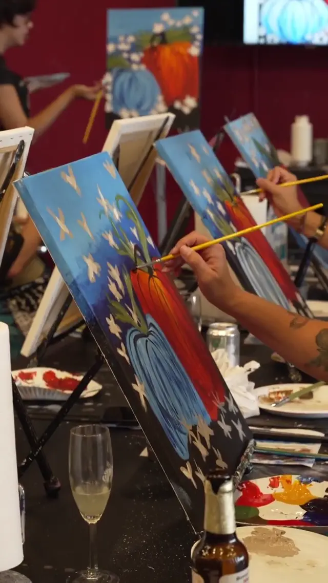 Students painting at their easels with Andrea teaching in the background