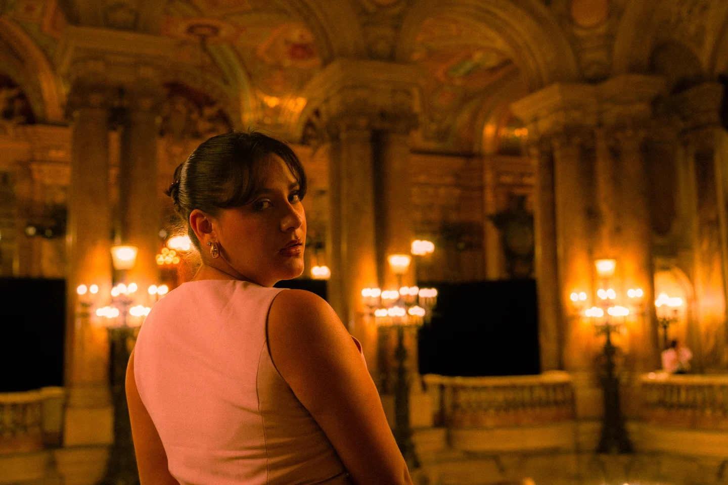 Andrea in an ornate, warmly lit Paris interior